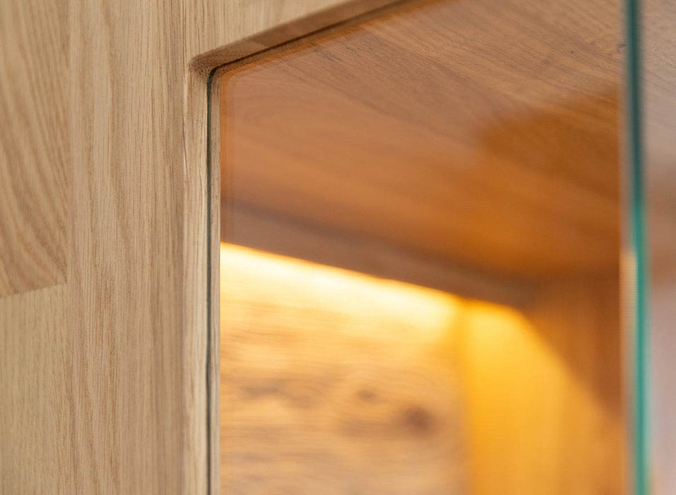 Beleuchtete Standvitrine aus massiver Eiche mit Lamellen | Wohnzimmerschrank Tirano II mit Rückwand in grober Holzstruktur -