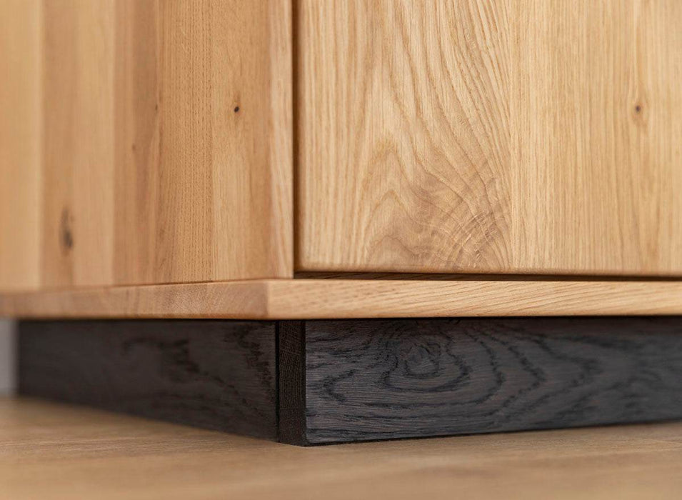 Beleuchtete Hängekommode aus massiver Eiche | TV-Board Tirano I mit Schaukasten und grober Holzstruktur -