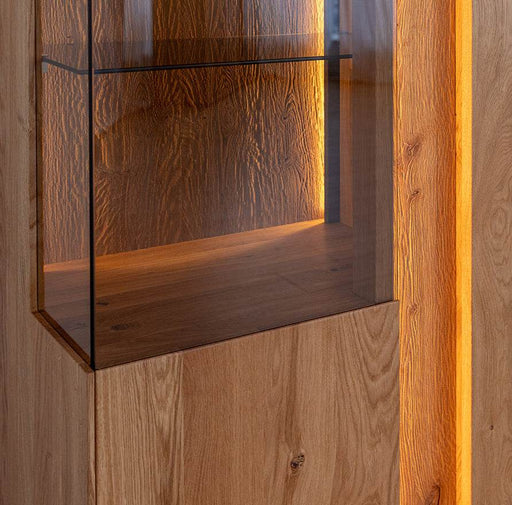 Beleuchteter Wohnzimmerschrank Collodi aus massiver Eiche mit Rückwand in grober Holzstruktur -