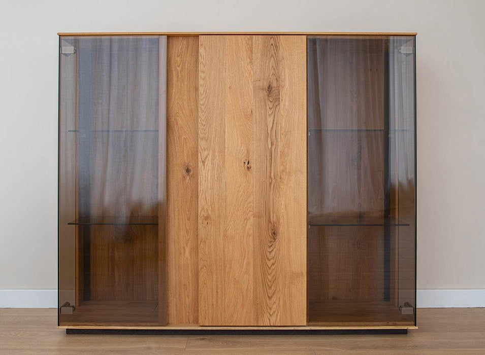 Beleuchtete Vitrinen Kommode Collodi aus massiver Eiche mit Rückwand in grober Holzstruktur -