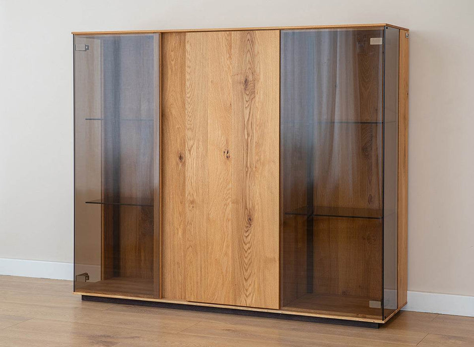 Beleuchtete Vitrinen Kommode Collodi aus massiver Eiche mit Rückwand in grober Holzstruktur -