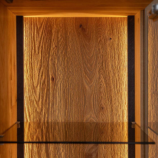 Beleuchtete Vitrinen Kommode Collodi aus massiver Eiche mit Rückwand in grober Holzstruktur -