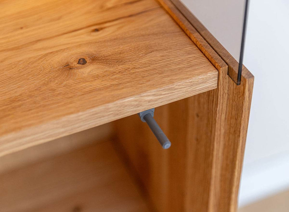 Beleuchtete Standvitrine Collodi aus massiver Eiche mit Rückwand in grober Holzstruktur -