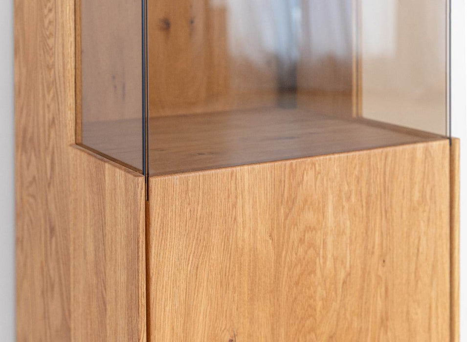 Beleuchtete Standvitrine Collodi aus massiver Eiche mit Rückwand in grober Holzstruktur -