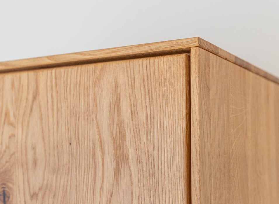 Beleuchtete Standvitrine Collodi aus massiver Eiche mit Rückwand in grober Holzstruktur -