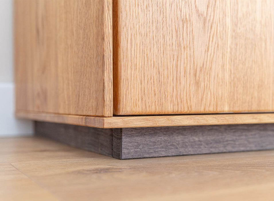 Beleuchtete Standvitrine Collodi aus massiver Eiche mit Rückwand in grober Holzstruktur -