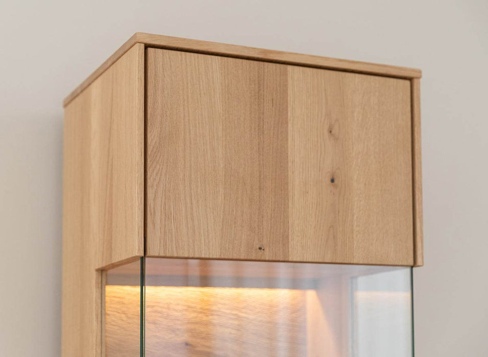 Beleuchtete Hängevitrine aus massiver Eiche | Vitrine Tirano I mit Rückwand in grober Holzstruktur -