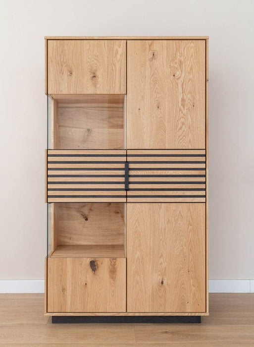 Beleuchtete Standvitrine aus massiver Eiche mit Lamellen | Wohnzimmerschrank Tirano II mit Rückwand in grober Holzstruktur -