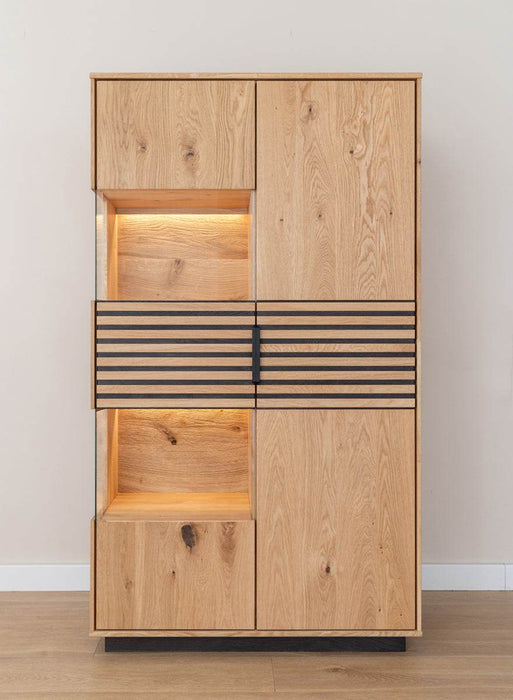 Beleuchtete Standvitrine aus massiver Eiche mit Lamellen | Wohnzimmerschrank Tirano II mit Rückwand in grober Holzstruktur -