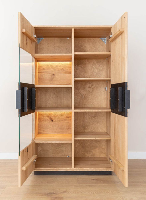 Beleuchtete Standvitrine aus massiver Eiche mit Lamellen | Wohnzimmerschrank Tirano II mit Rückwand in grober Holzstruktur -