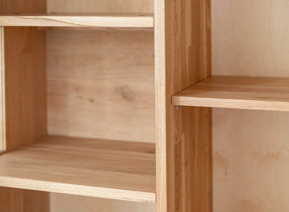 Beleuchtete Standvitrine aus massiver Eiche mit Lamellen | Wohnzimmerschrank Tirano II mit Rückwand in grober Holzstruktur -