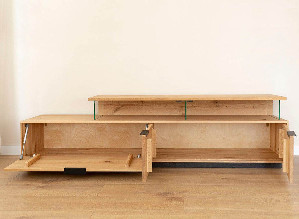 Beleuchtete Hängekommode aus massiver Eiche | TV-Board Tirano I mit Schaukasten und grober Holzstruktur -