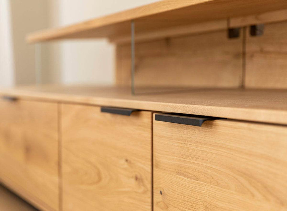 Beleuchtete Hängekommode aus massiver Eiche | TV-Board Tirano I mit Schaukasten und grober Holzstruktur -