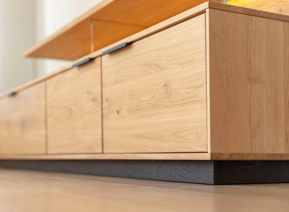 Beleuchtete Hängekommode aus massiver Eiche | TV-Board Tirano I mit Schaukasten und grober Holzstruktur -