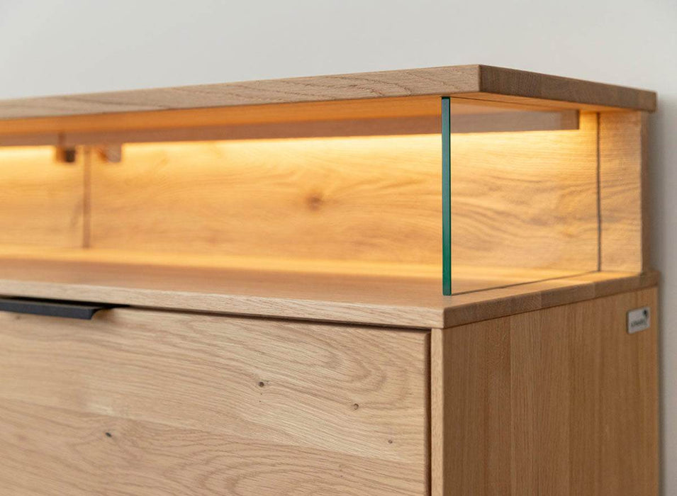 Beleuchtete Hängekommode aus massiver Eiche | TV-Board Tirano I mit Schaukasten und grober Holzstruktur -