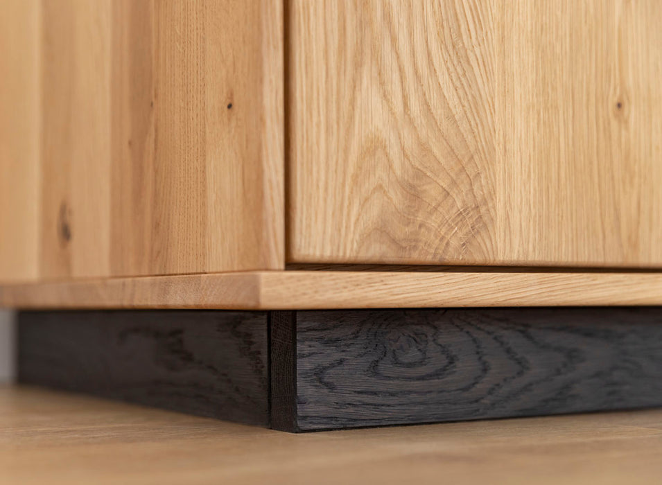 Beleuchtete Hängekommode aus massiver Eiche | TV-Board Tirano I mit Schaukasten und grober Holzstruktur