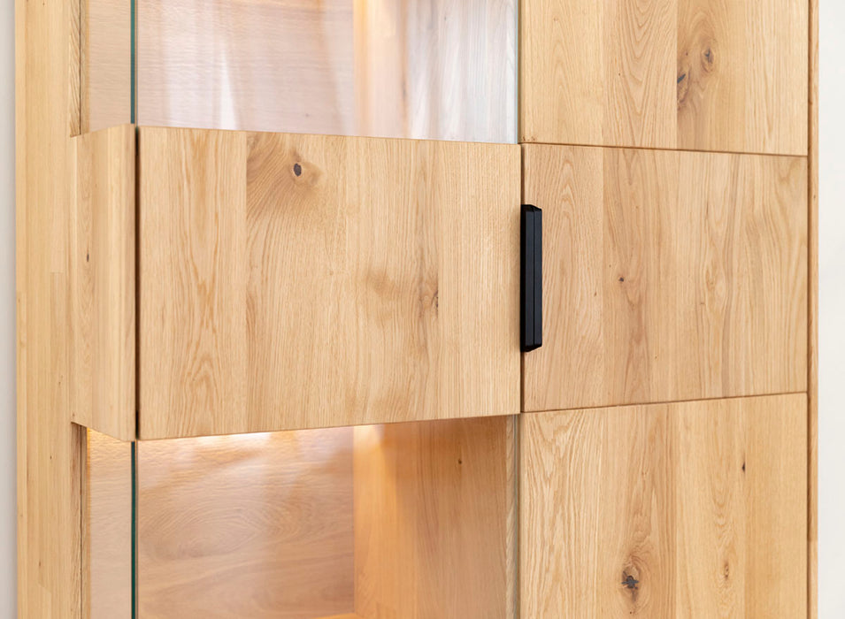 Beleuchtete Standvitrine aus massiver Eiche | Wohnzimmerschrank Tirano I mit Rückwand in grober Holzstruktur