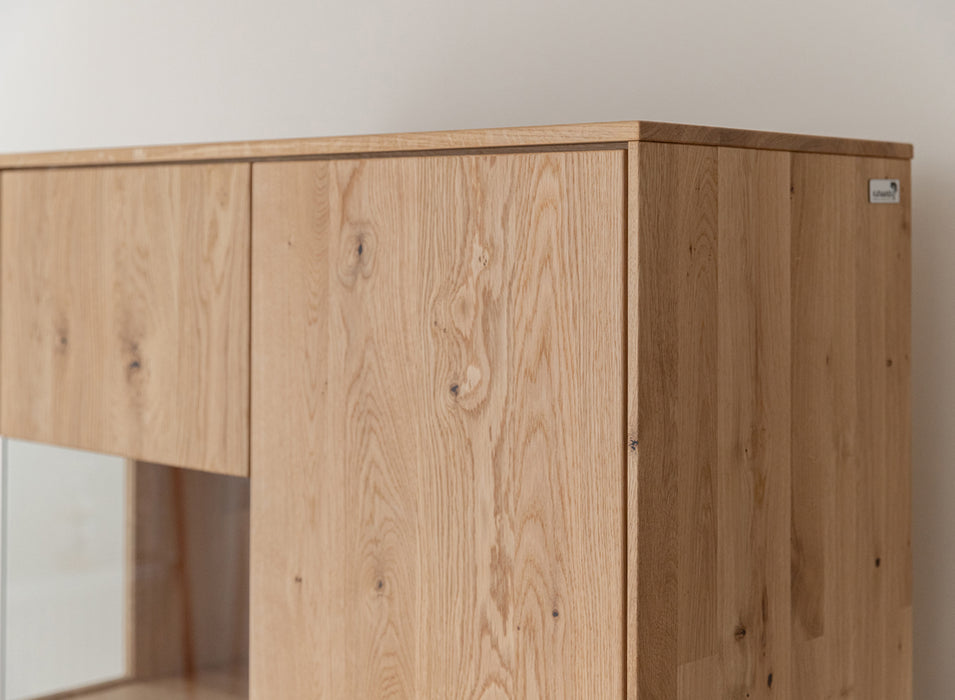 Beleuchtete Standvitrine aus massiver Eiche mit Lamellen | Wohnzimmerschrank Tirano II mit Rückwand in grober Holzstruktur
