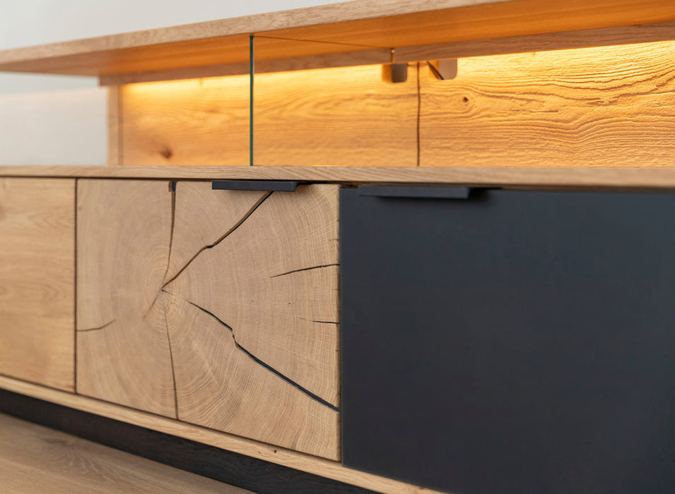 Beleuchtete Hängekommode aus massiver Eiche und Glas | TV-Board Tirano IV mit Schaukasten und grober Holzstruktur