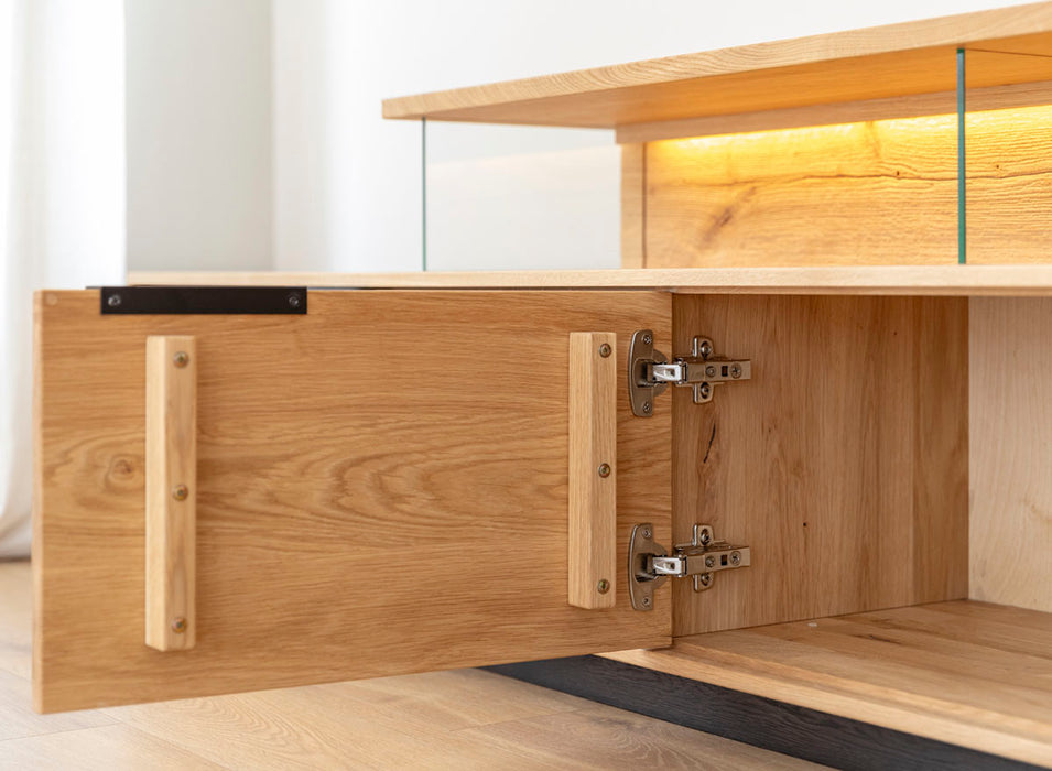 Beleuchtete Hängekommode aus massiver Eiche | TV-Board Tirano I mit Schaukasten und grober Holzstruktur