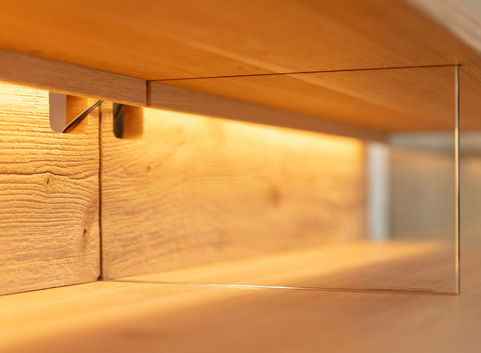 Beleuchtete Hängekommode aus massiver Eiche | TV-Board Tirano I mit Schaukasten und grober Holzstruktur